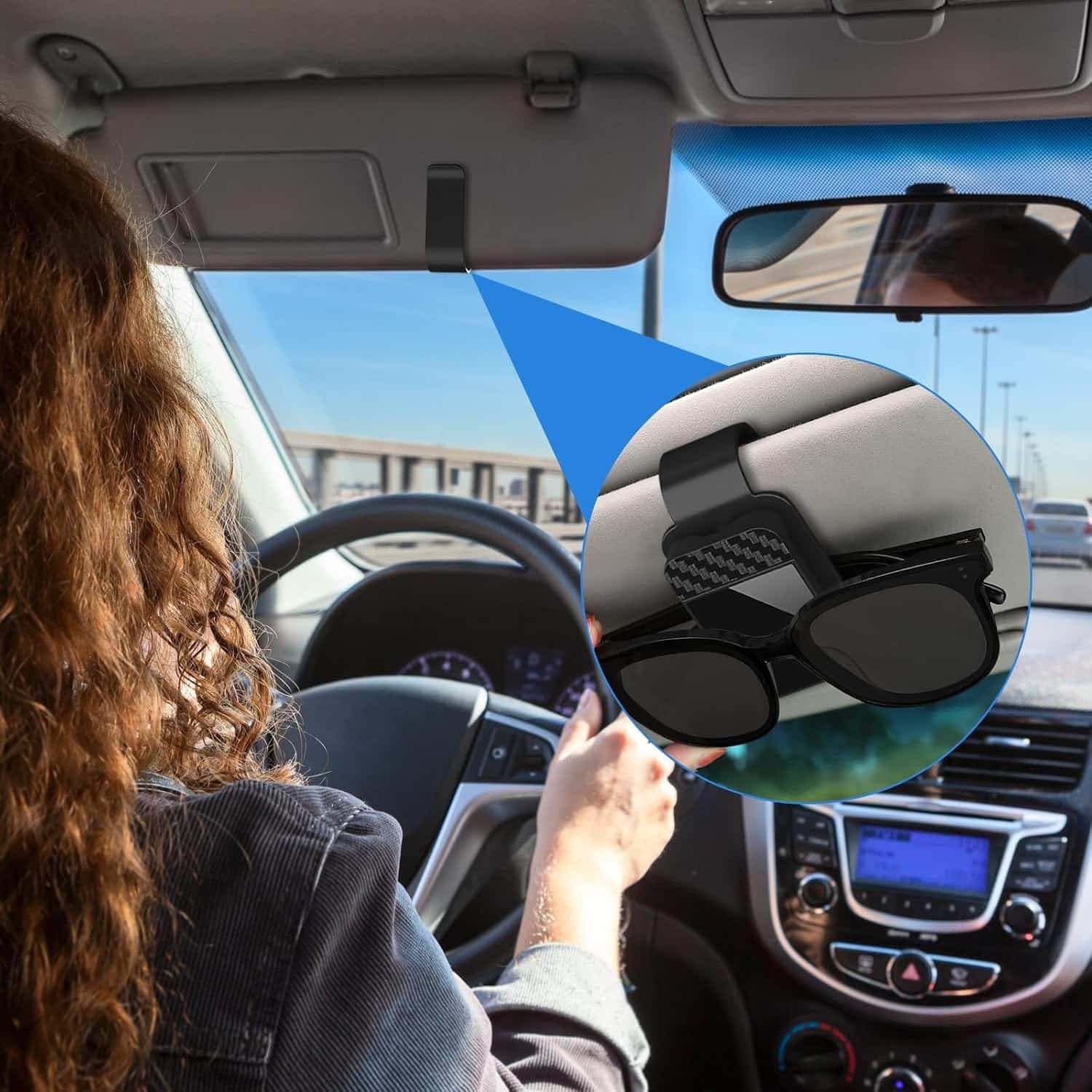 Brillenhouder aan de zonneklep in het interieur van een auto
